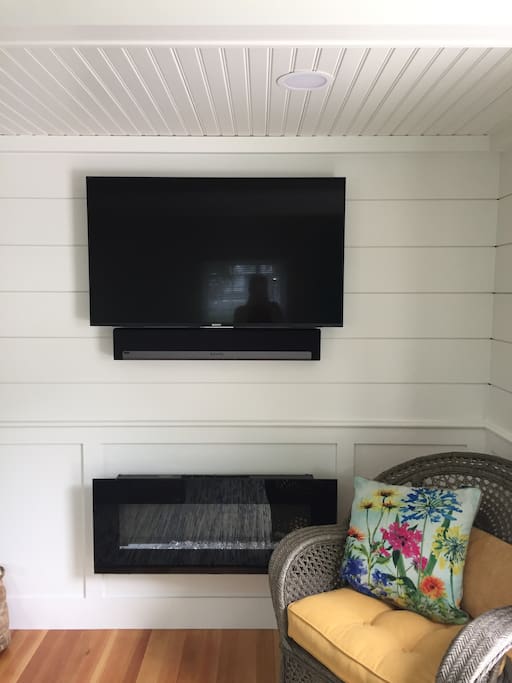 Flat screen with Sonos sound bar and electric fireplace.