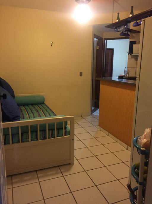 Sala com sofá cama, ventilador e televisão