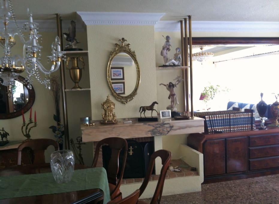 salon comedor con chimenea aire acondicionado y calefacción, con vistas al jardín