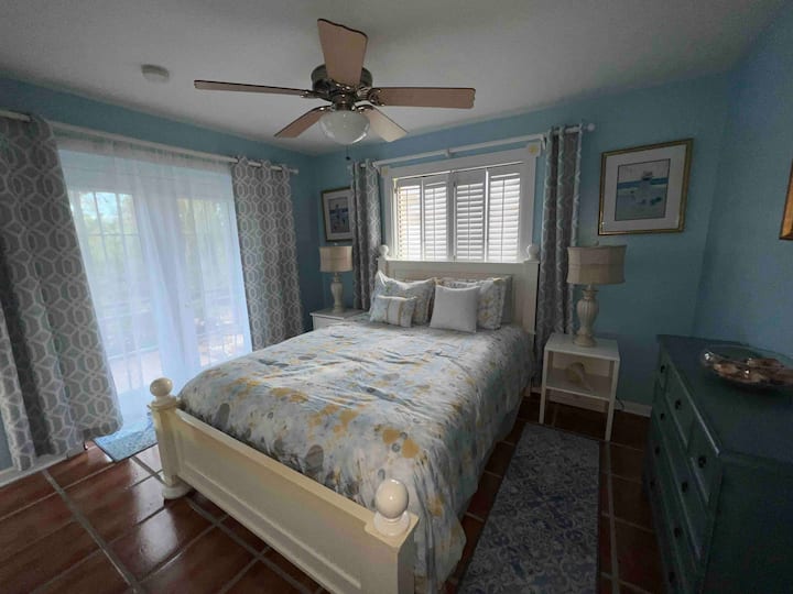 Chumba cha kulala cha tatu kilicho na kitanda cha Queen, kabati la kuingia na milango ya Kifaransa inayoelekea kwenye eneo la lanai