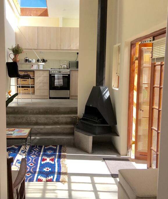 Steps leading to kitchen area, storage cupboard and bathroom.