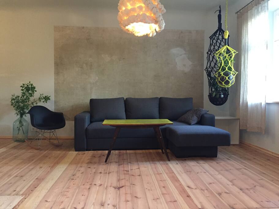 This blank wall was so good we just could not paint it away. So we kept it as it is. Latvian "Mamma lampa" paper lamp, macrame plant holders Lucille by german brand LLOT LLOV, original mid century modern table and fake Eams rocking chair.