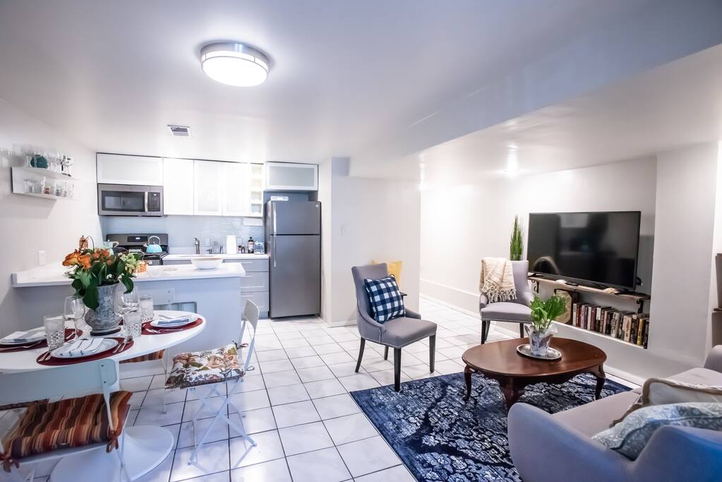 Spacious, ready to use kitchen with island, Roku television on hand made shelves and stylishly decorated living room.