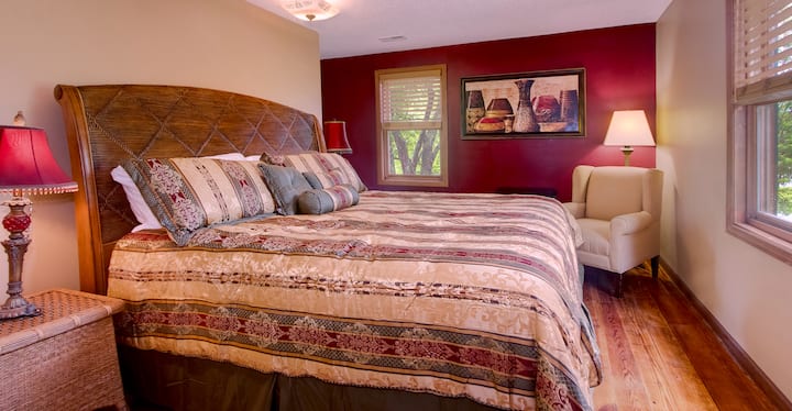 En el piso de arriba hay un rico dormitorio con cama tamaño king rojo y dorado