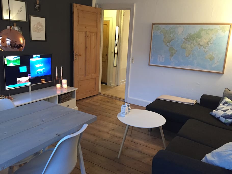 Living room with tv, couch with chaise lounge and dinner table