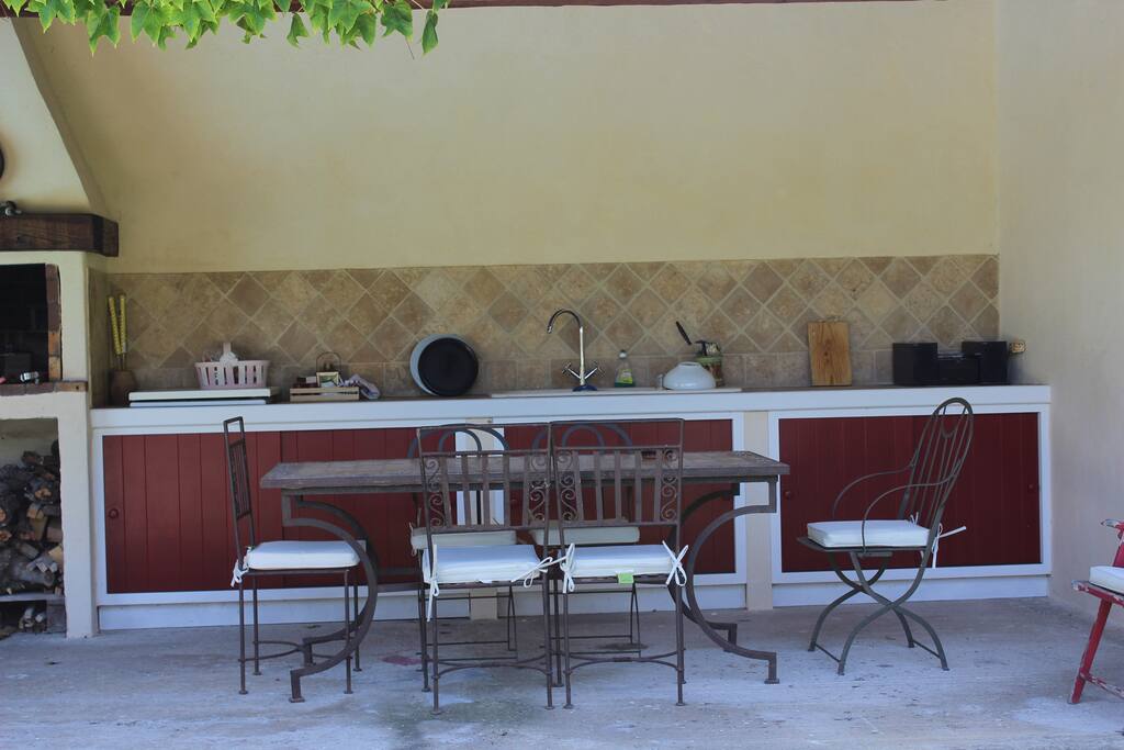 Pool house, table, 6 chaises en fer forgé, barbecue, évier, plaque de cuisson et placards de rangement pour la vaisselle