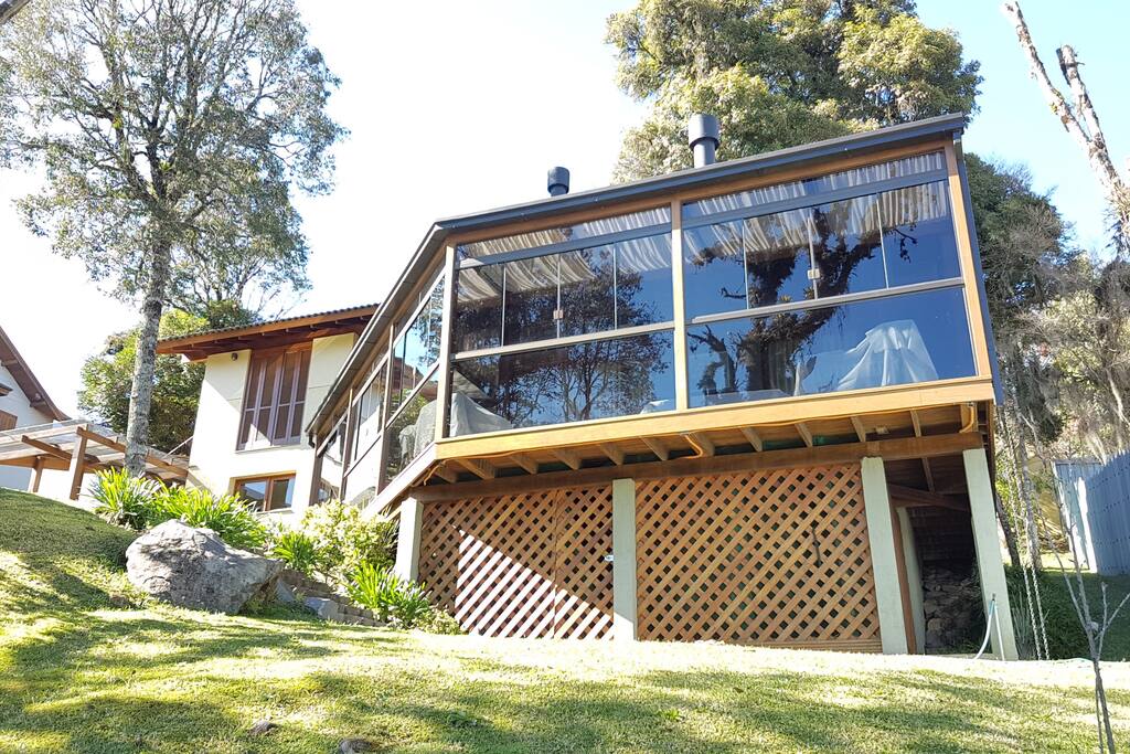 Casa com deck envidraçado em meio a natureza