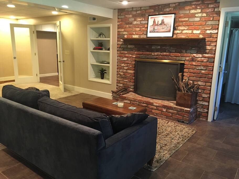 Wood burning fireplace. Cozy up on the modern velvet 6 foot couch(bring linens for 5th person to sleep on couch). Natural light from double hung windows. Bathroom is on right. French doors on left open to pool table, kitchen and dining area.