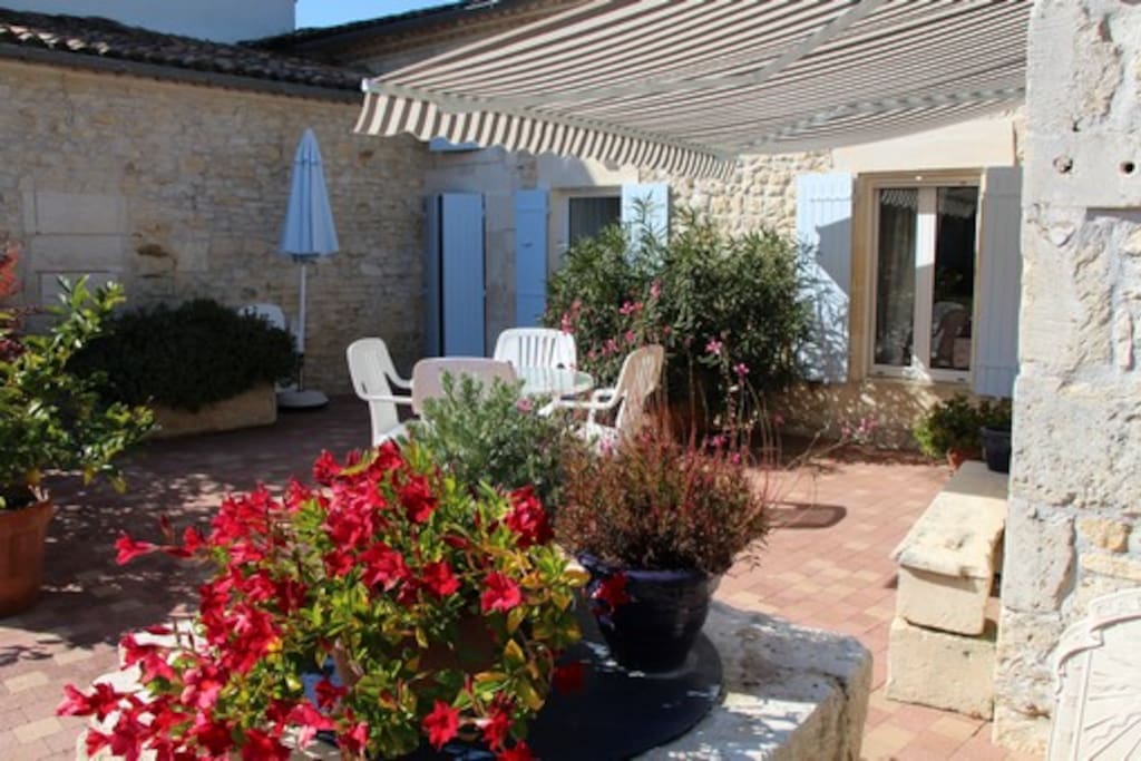 Terrasse fleurie, ombragée par un store