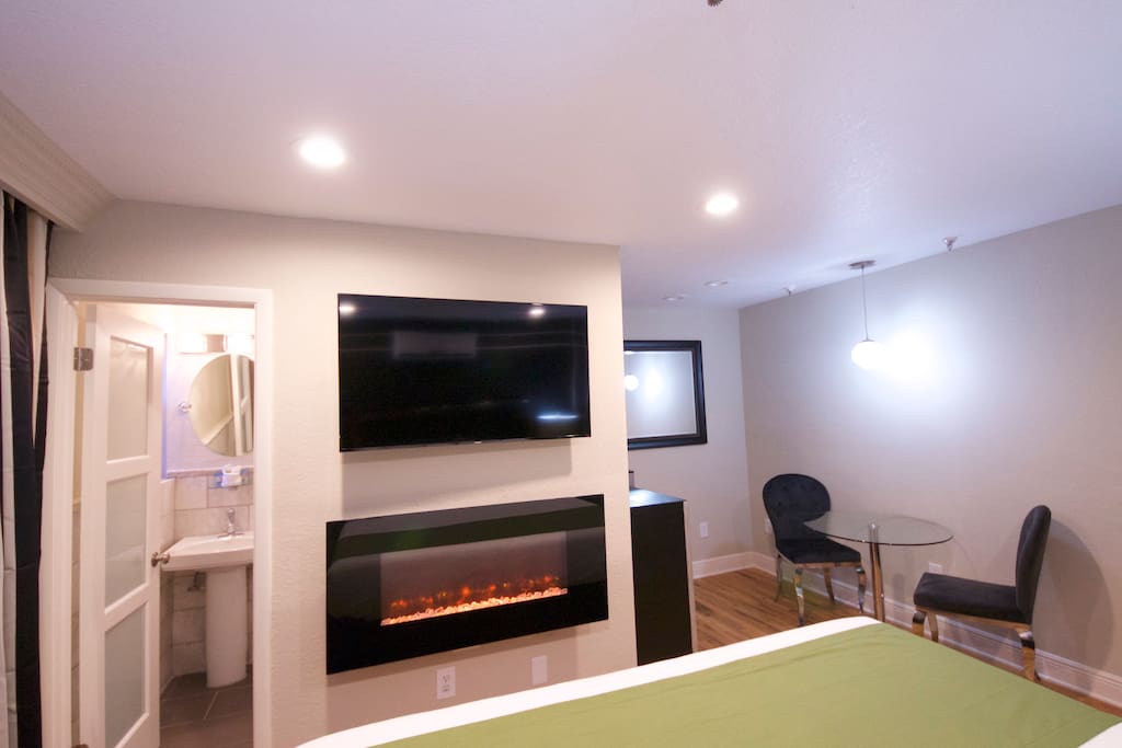 View of large flat screen television & wall mounted fireplace