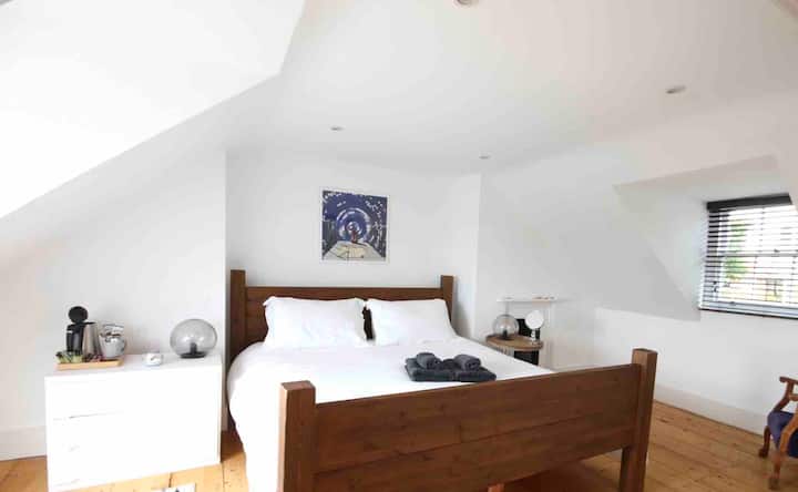 Pana chumba cha kulala cha ghorofa ya juu na balcony inayoangalia paa na nje ya bahari! 