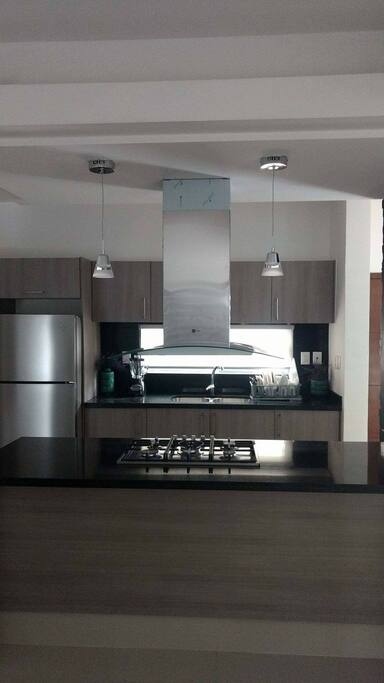 amplia cocina con todo, licuadora horno microondas horno estufa refrigerador y utensilios para cocinar