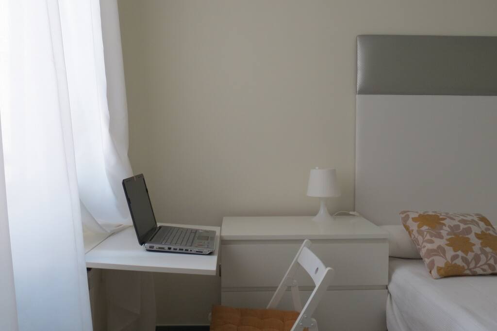 Mesa de trabajo en dormitorio. Luz natural.