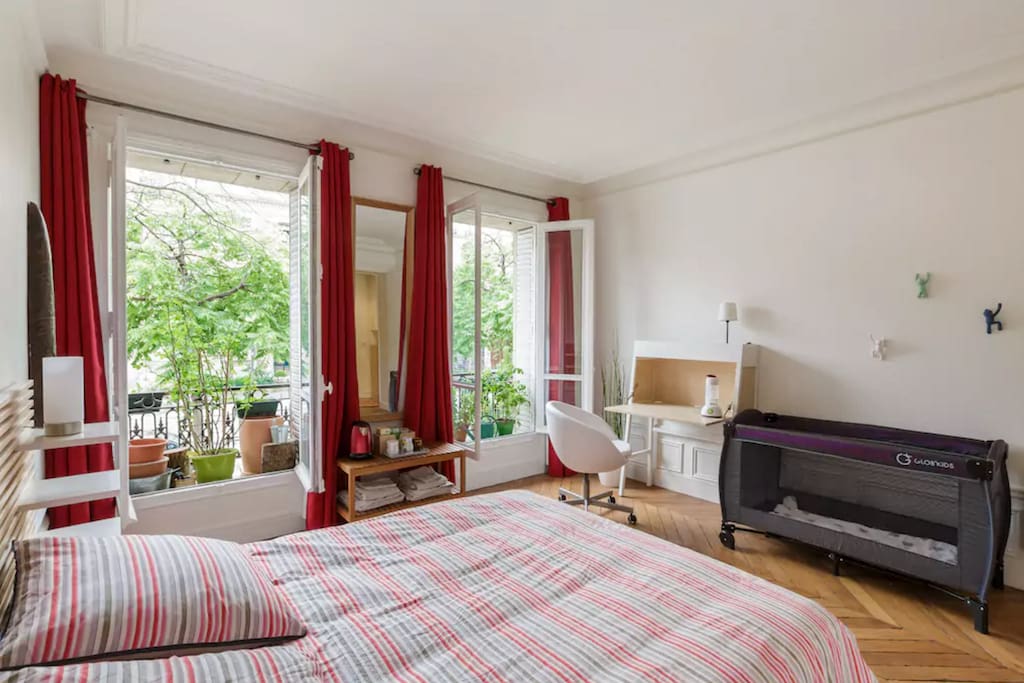 Master bedroom with desk and baby crib