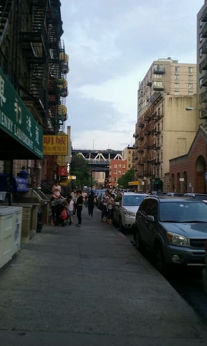 That is indeed the Manhattan Bridge, Brooklyn Bridge is also walking distance. That green awning is indeed a laundromat.