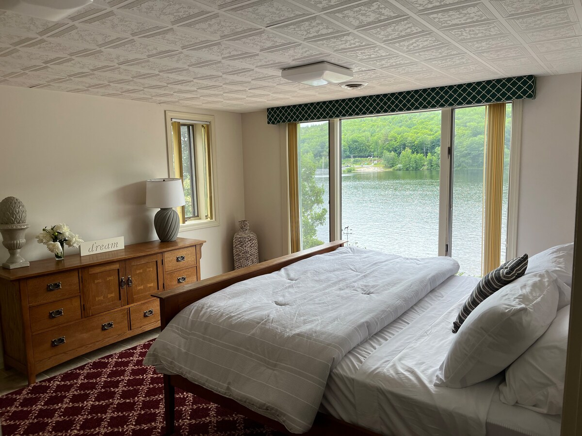 Spálňa s manželskou posteľou na prízemí s krásnym výhľadom na jazero a most Shaker