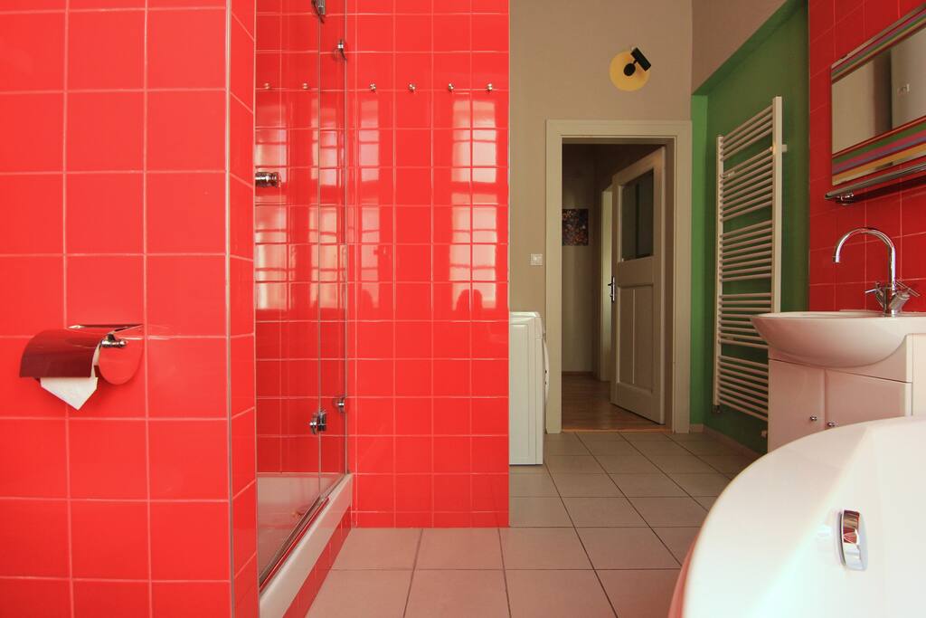 Bathroom has a stand-up shower and a big corner bath tub