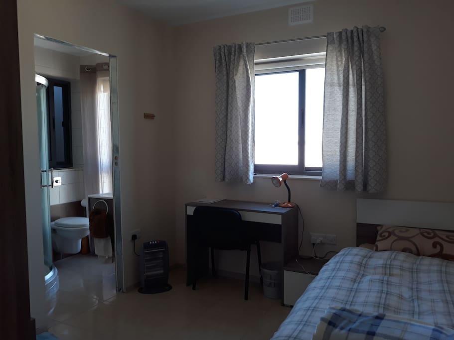 single room with desk bed side table and wardrobe