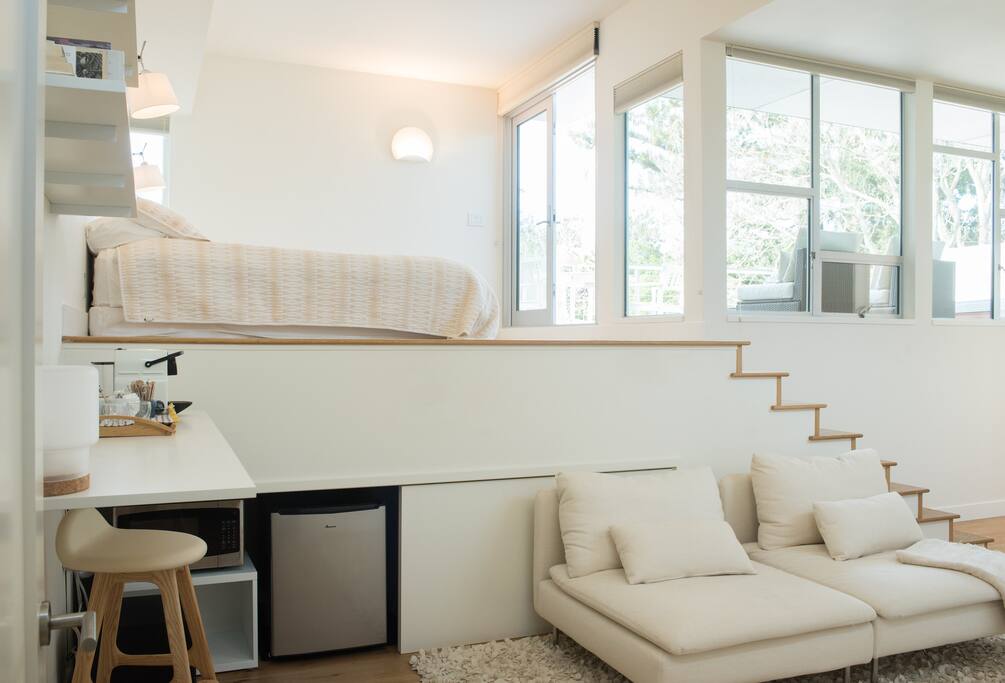 The fridge and microwave are located under the bedroom loft.
