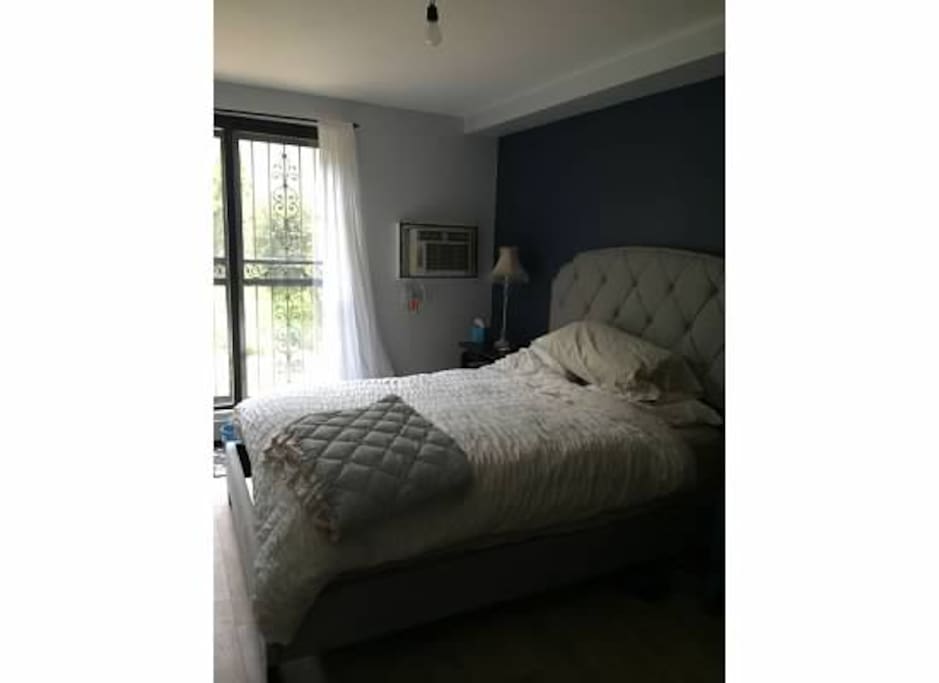 Master bedroom with door to backyard and queen pillow-top mattress