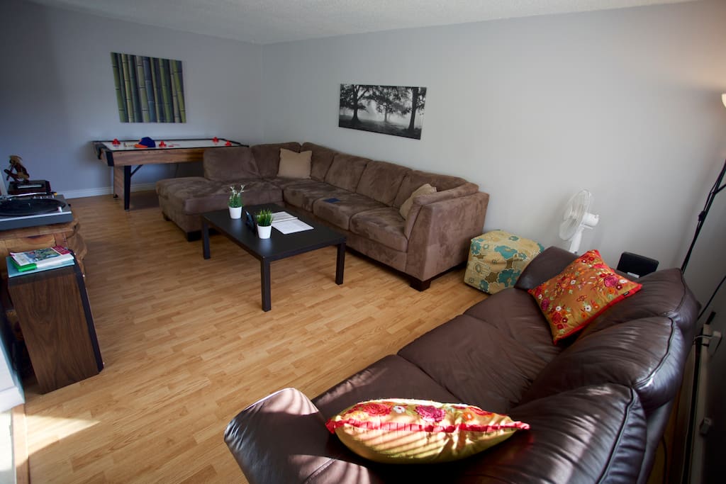 Living room with 1 large sectional and 1 leather couch.