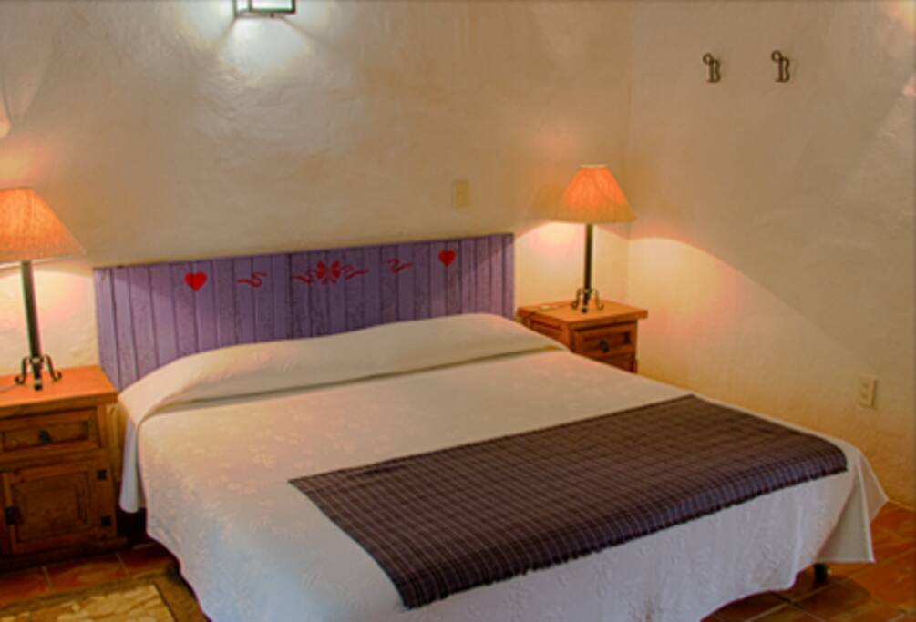 Habitación Morada: una cama king size y una individual con baño completo.