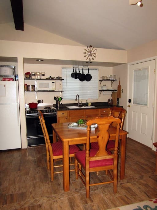 Kitchen w/full size fridge, stove, sink, microwave. Pots and pans and dinnerware included.