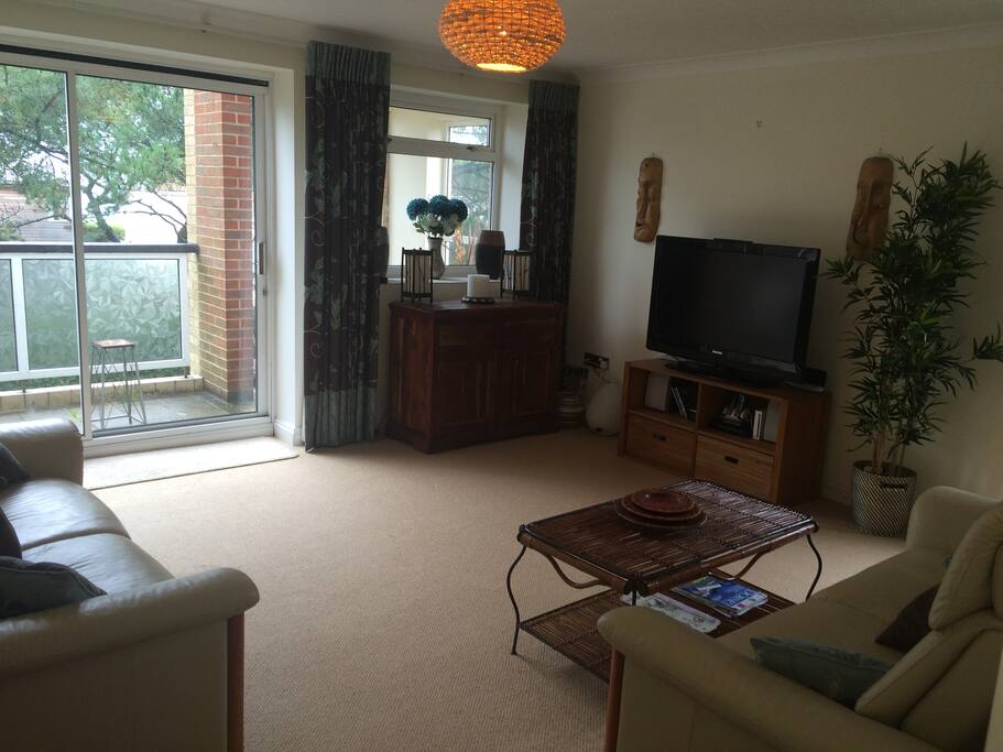 Spacious lounge leading onto a part covered balcony with sea glimpses.
