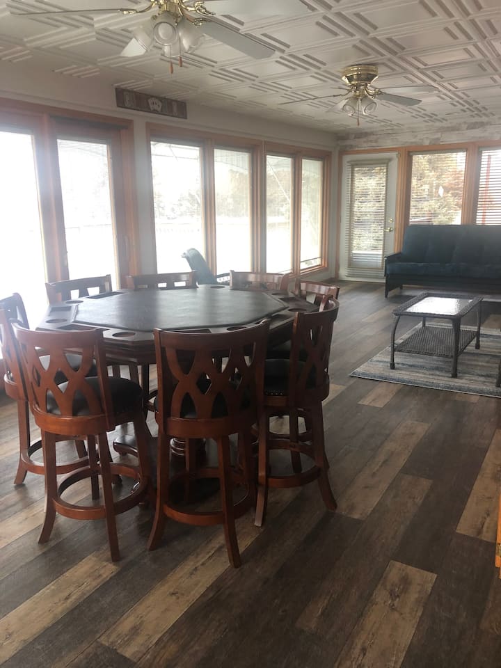 Game room with 8 person poker table, full size futon and sliding glass door out to front deck.