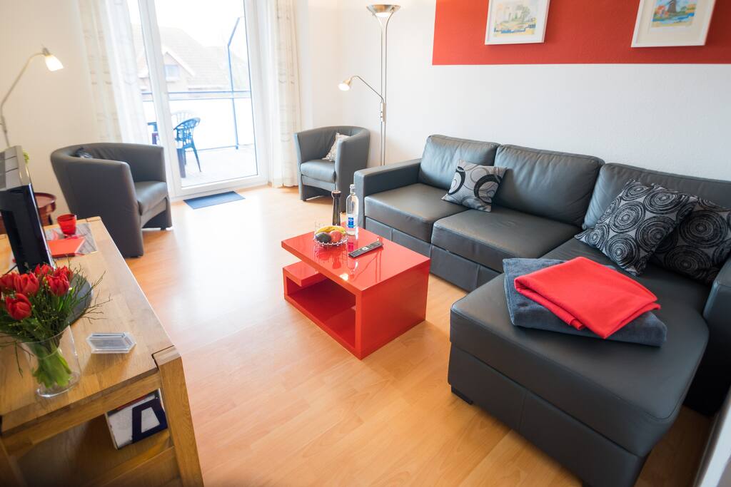 Wohnzimmer mit angrenzendem Südbalkon und Schlafcouch