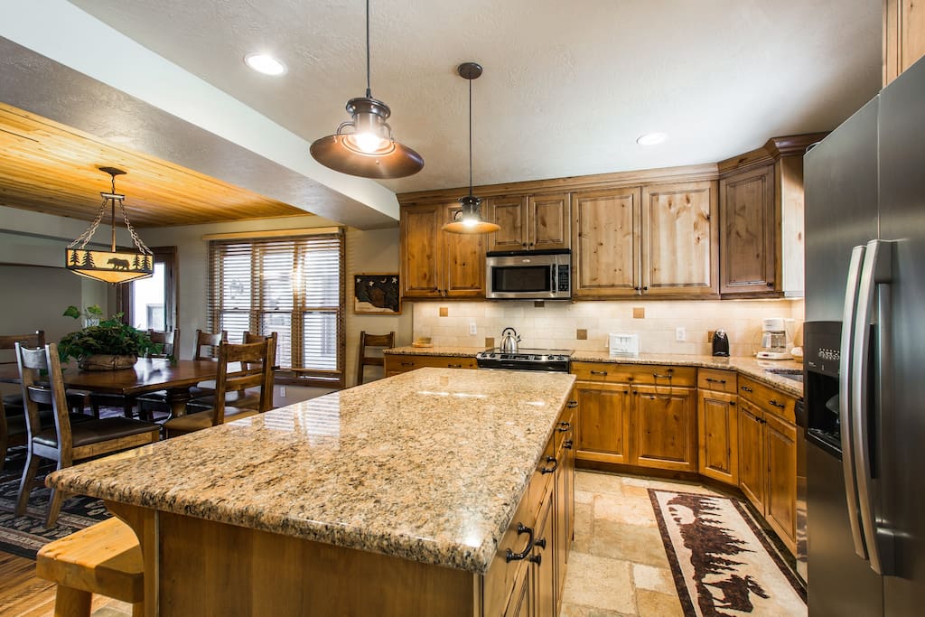 The kitchen is beautifully finished with thick granite countertops, hardwood cabinetry and a large kitchen island, which can also second as a breakfast bar with bar stool seating for four (4) people.