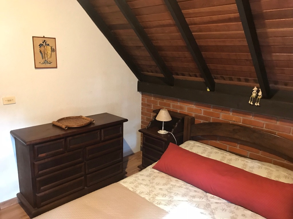 Slaapkamer 2 op de derde verdieping met een queensize bed en dressoir 