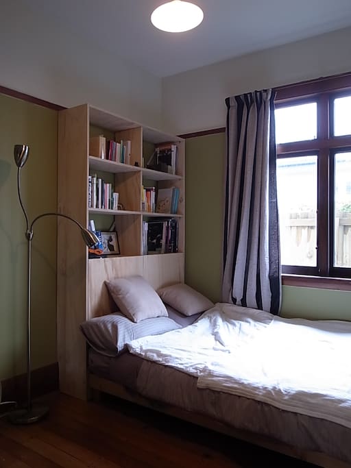 Your bedroom, with new bookshelf, small double bed and morning sun.