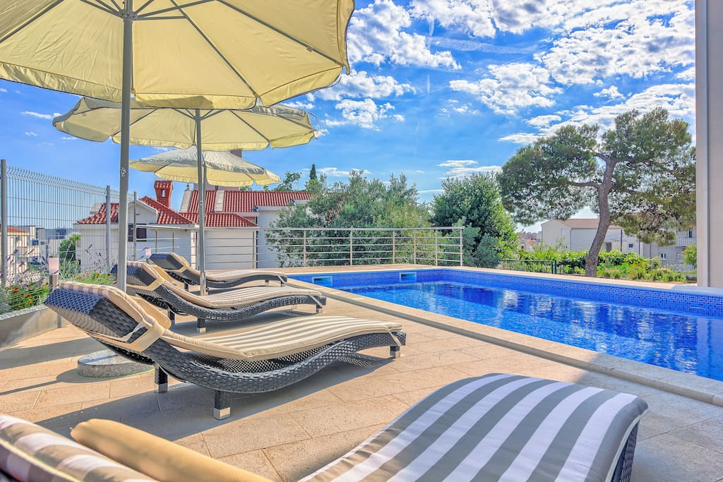 Pool area with loungers and parasols