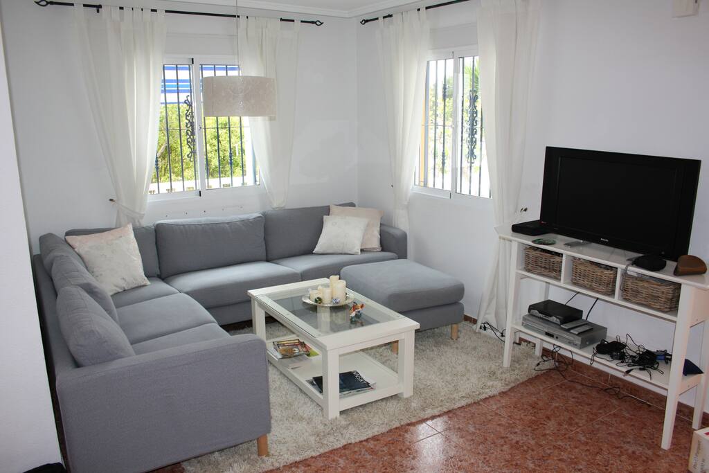Part of lounge with TV and sofa settee.
