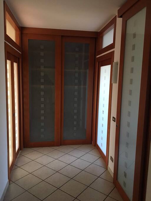 Ingresso con armadio a muro frontale e porte scorrevoli per la cucina e la sala a destra, reparto notte a sinistra.