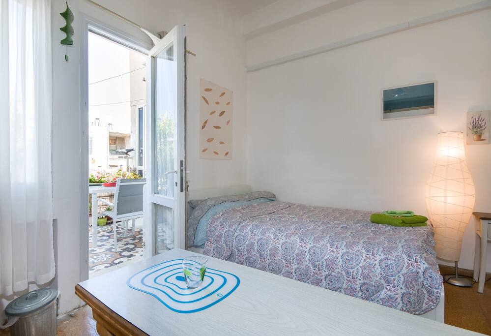 Overview of the room: double bed, 2 tables, 3 door closet+ a mirror, fan, arm chair and 2 chairs, 2 exits to balcony's