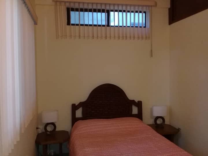 سرير مزدوج وطاولتان جانبيتان مع مصباحهما لكل منهما وأدوات زجاجية.