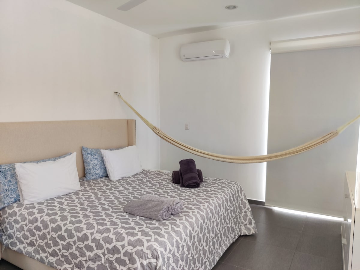 Mbedroom with king size bed, hamock, A/c, ceiling fan, lake views, and balcony.
Walk-in closet and bathroom