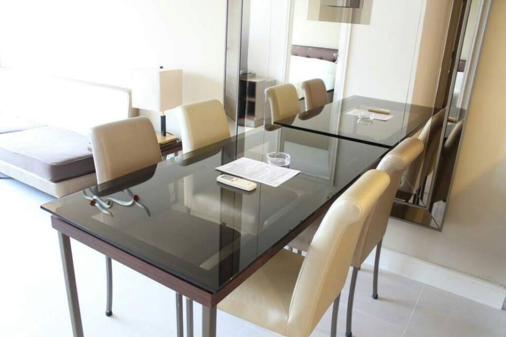 We have a spacious living room with a sofa, TV and big dining table.