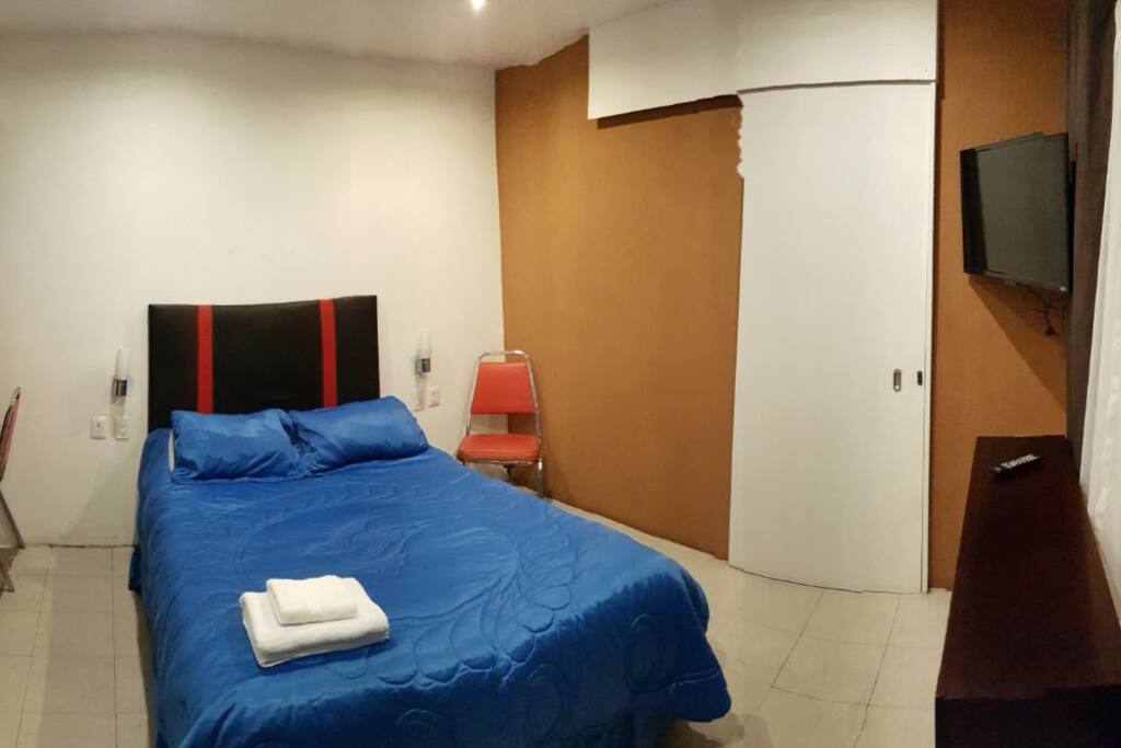 Bed and flat TV with local HD channels/Se ve la cama y una televisión plana con canales locales en HD
