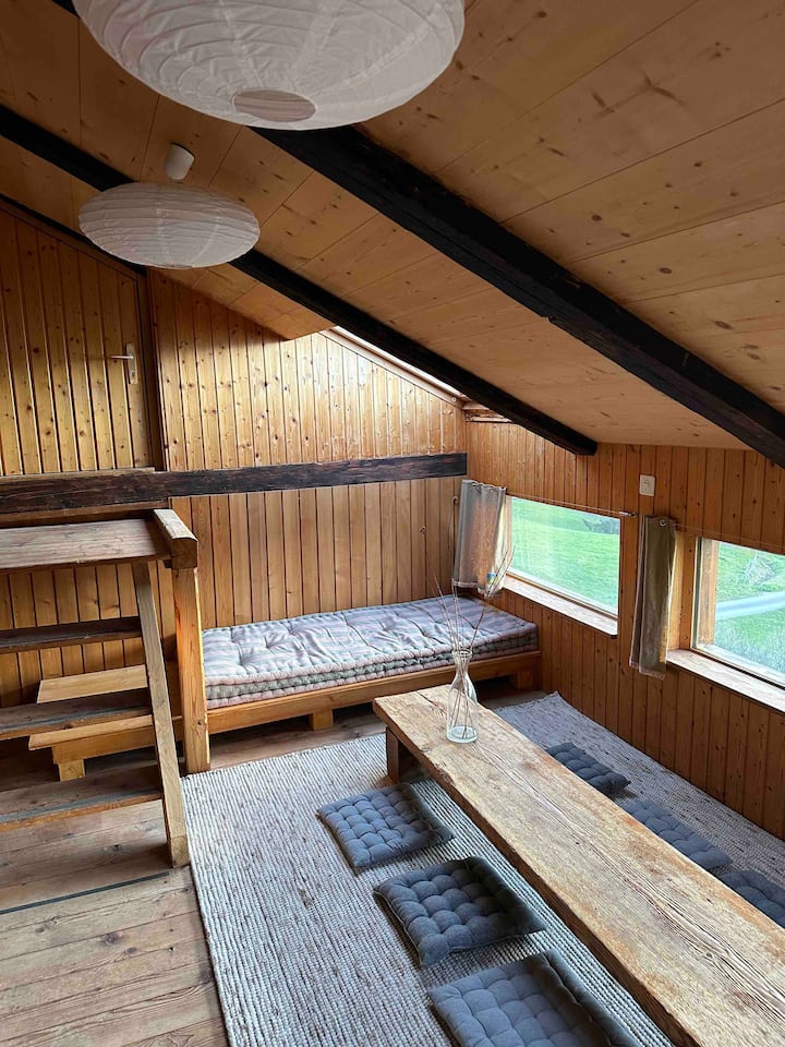 Afslappende stue på øverste etage. Fantastisk som legeplads, til læsning, teambriefing eller et måltid med udsigt over dalen. Begge bænke kan fungere som en ekstra seng efter anmodning.