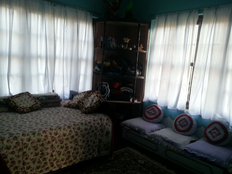 The room with double bed, comfortable mattress, Enough pillows, low sofa, Room sized rack and a table
