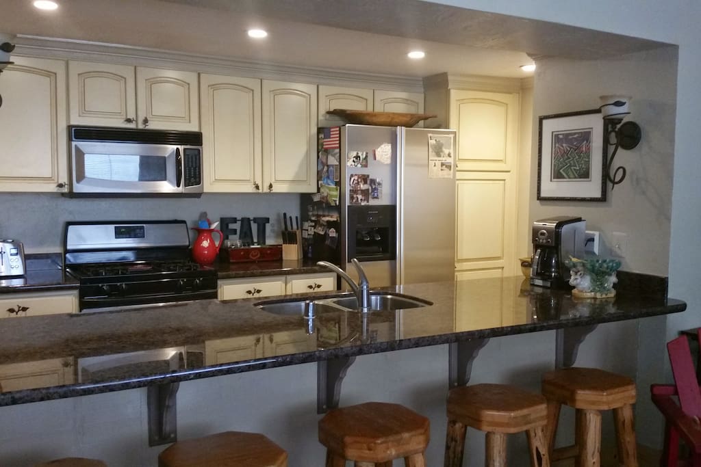 Updated kitchen with granite counter and 5 bar stools