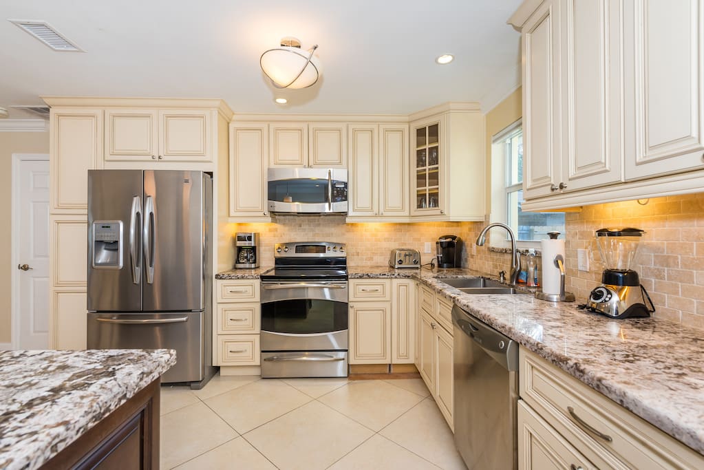 Marble countertops and high-end stainless steel appliances shine in the well-equipped kitchen.