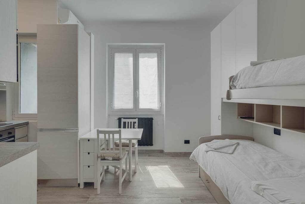 Panoramica camera da letto con ampia finestra e scrivania