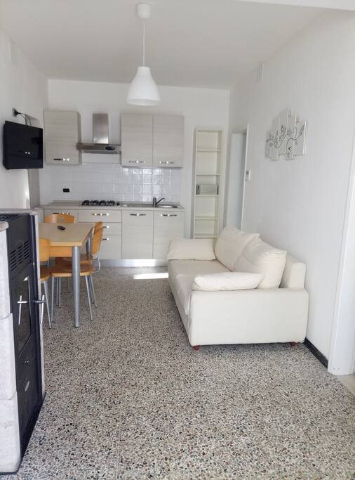 Zona giorno con divano, tavolo 4/6 posti e TV