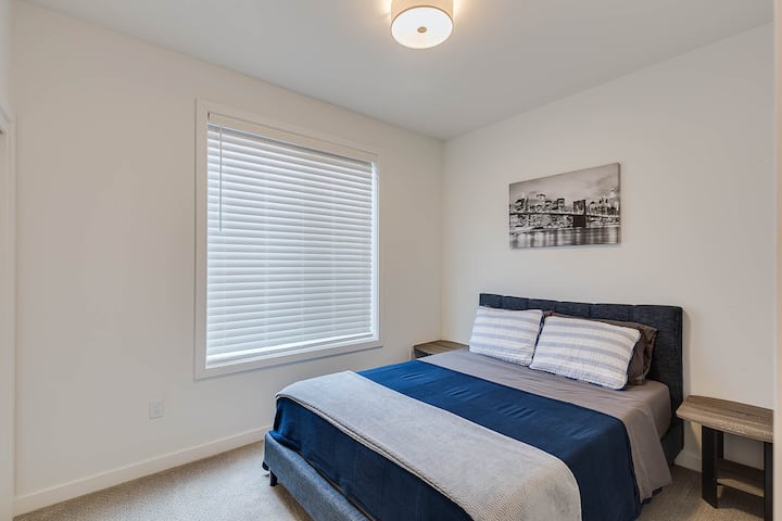 Cama tamaño queen con mesitas de noche y todas las sábanas