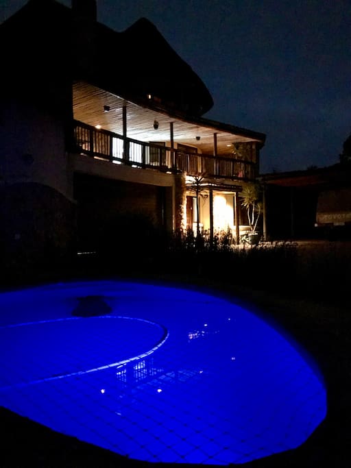 Pool at night with house