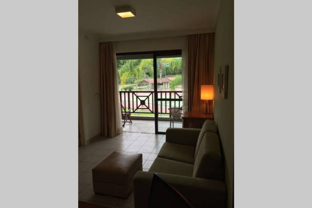 Sala com cozinha americana e sofá cama